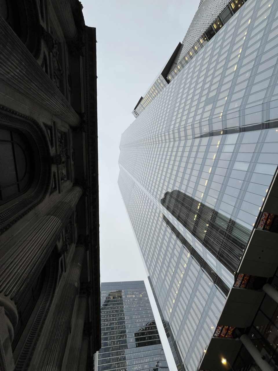 Glass tower rising beside an older stone facade